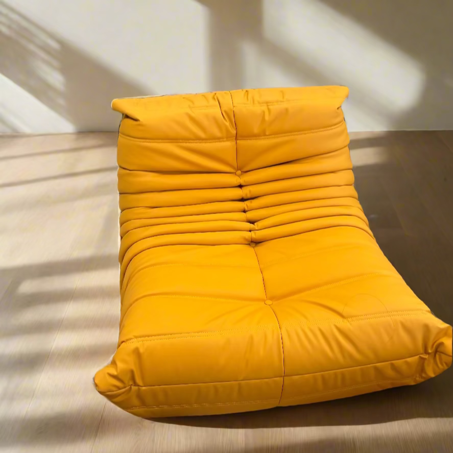 Yellow lounge chair in a room with colorful decor and furniture.