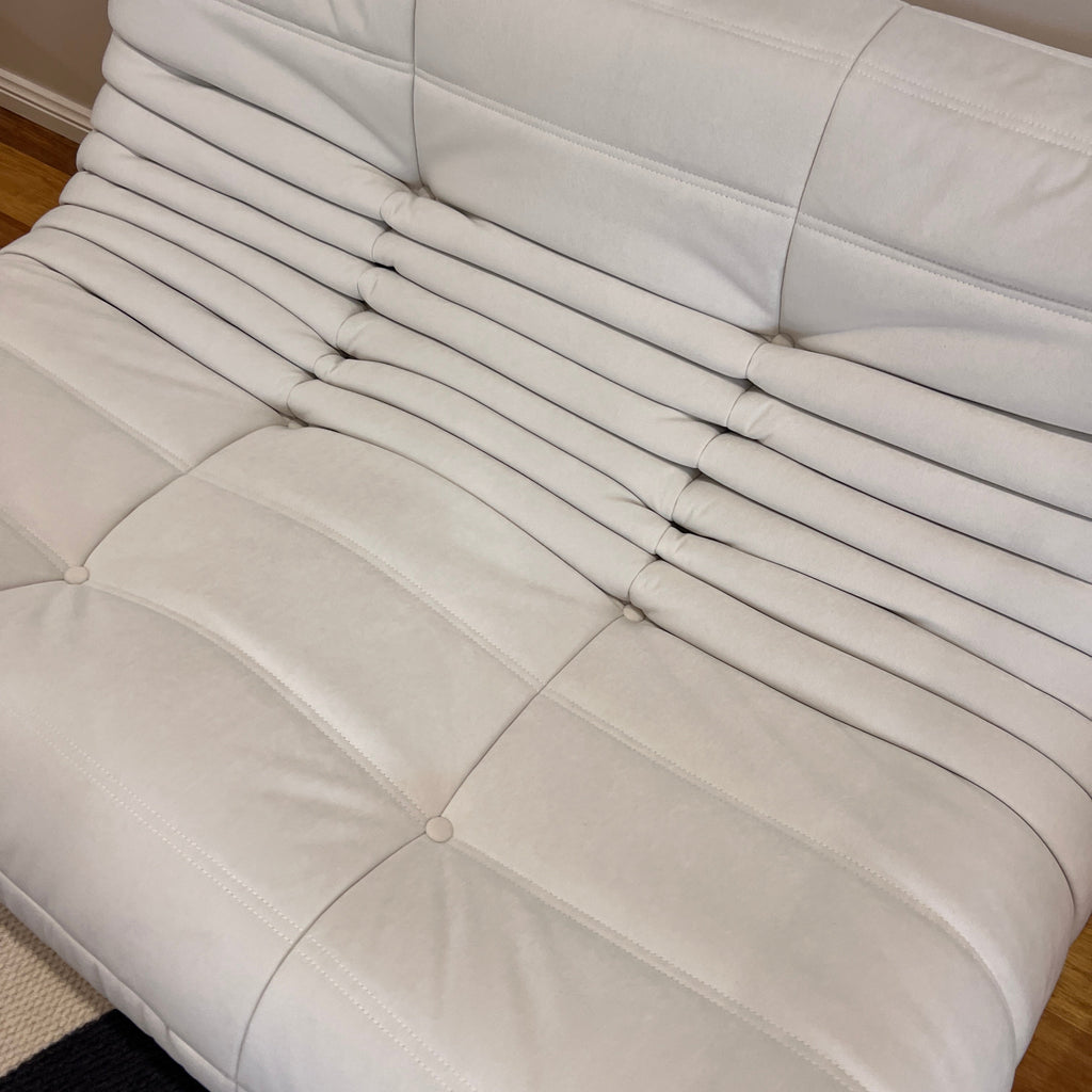 Close-up of a white quilted jacket with a neutral background