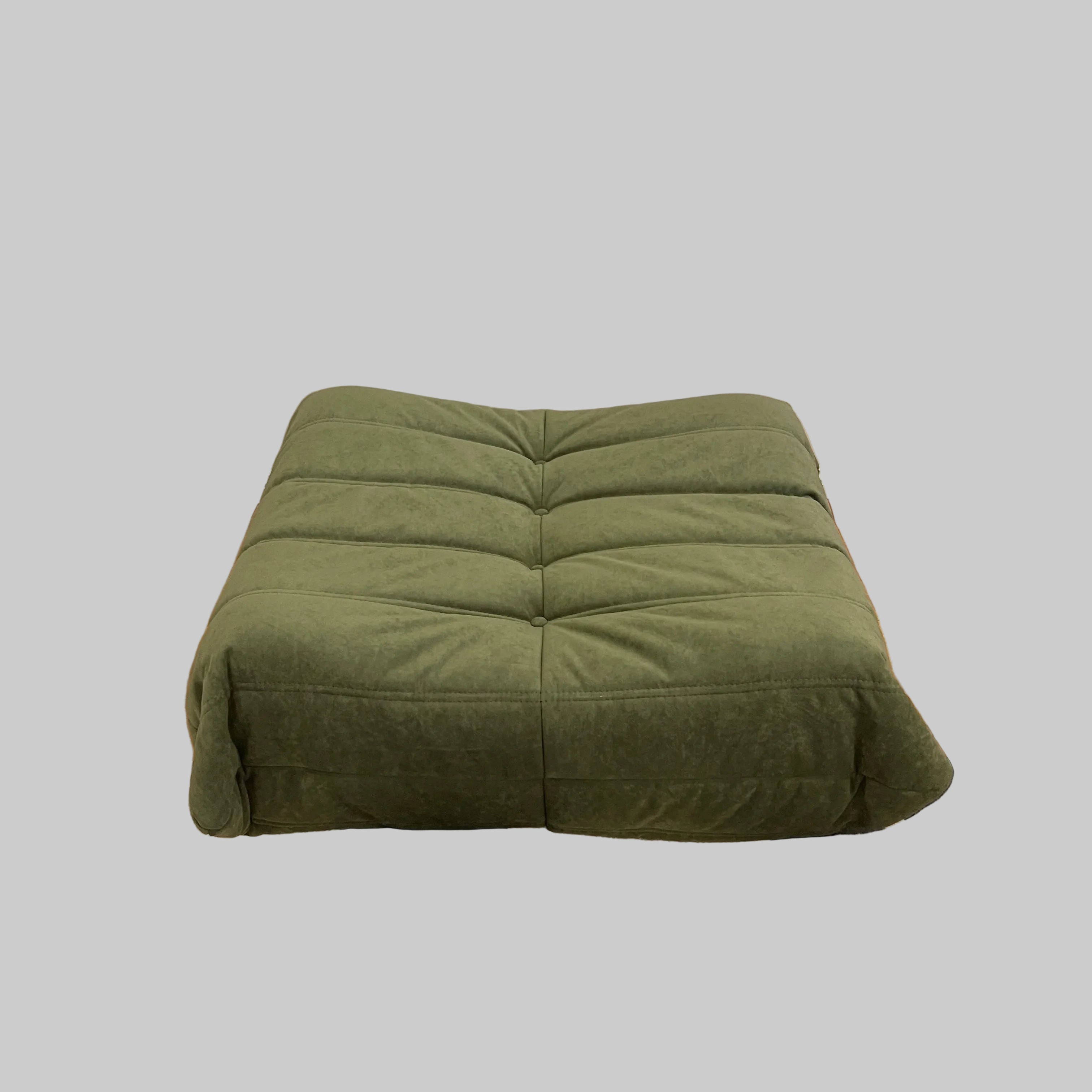 Green cushion on a wall next to a black and white patterned rug