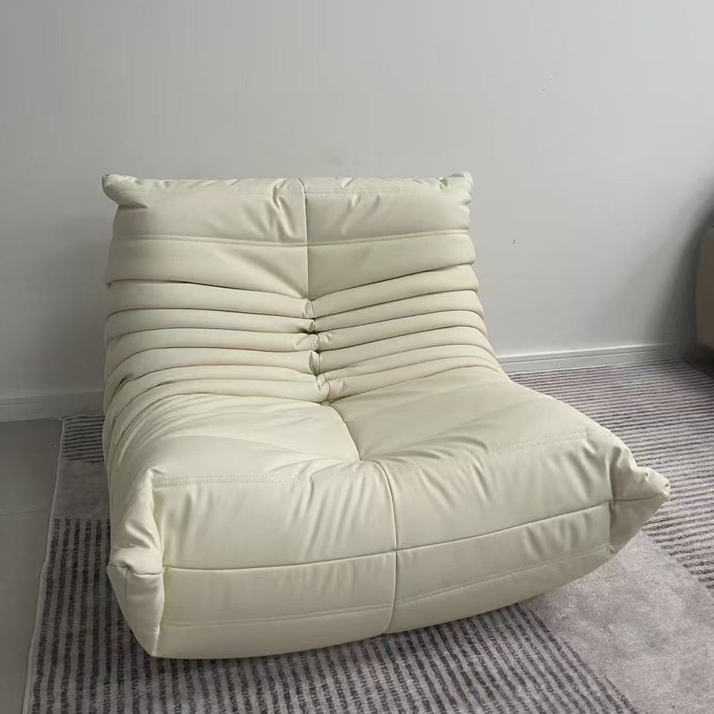 Cream-colored bean bag chair on a gray carpet with a white wall background