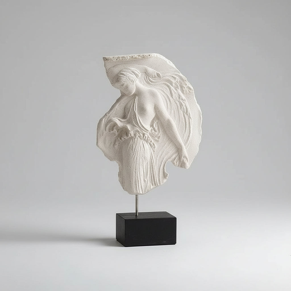 Decorative items on a wooden surface including a book, sculpture, and vase with flowers.