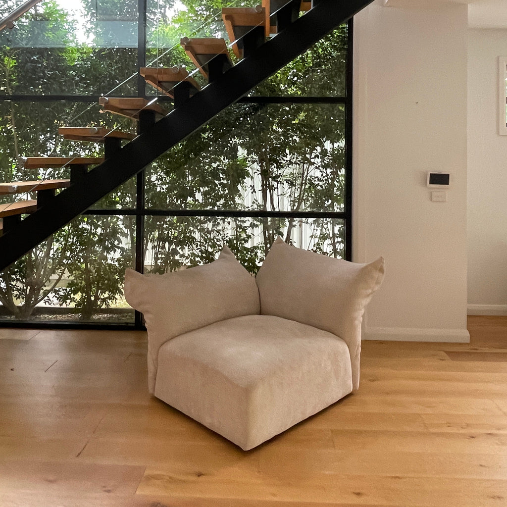 Modern interior with a staircase and a sofa in a room with large windows.