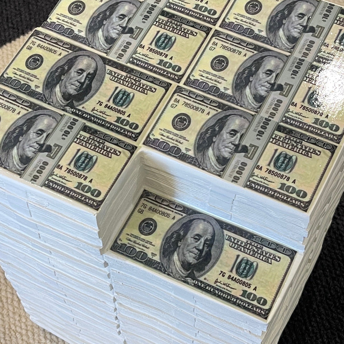Money stack side table on a black and beige patterned rug