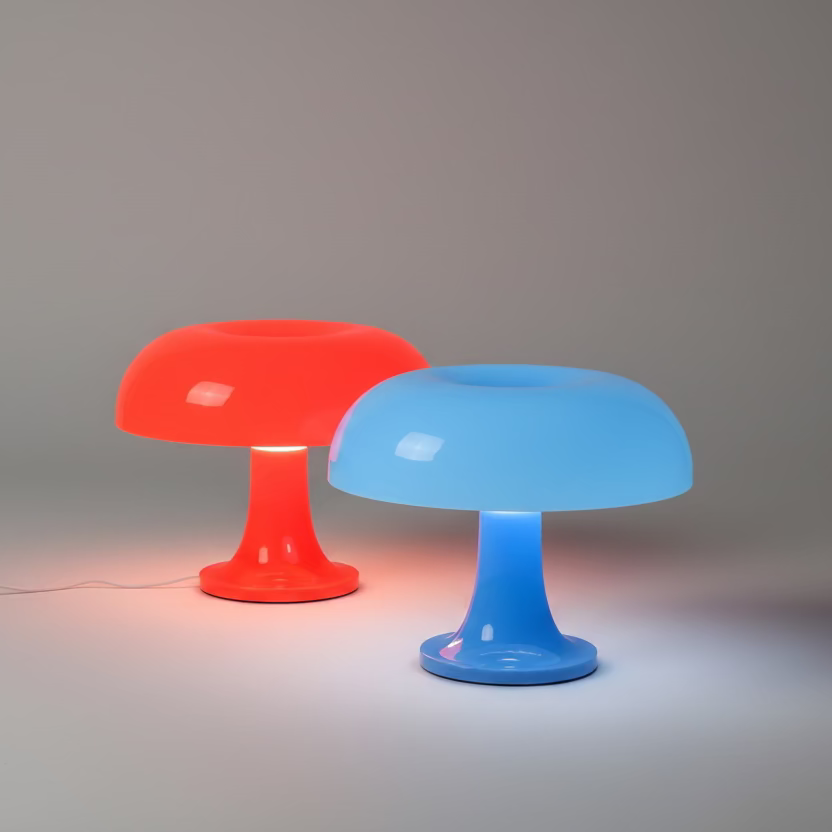Two colorful table lamps, one red and one blue, on a marble surface.