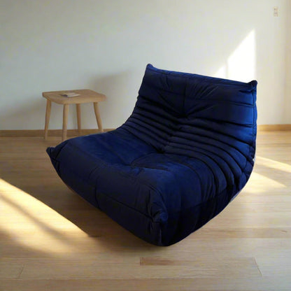 Blue bean bag chair on a wooden floor with a colorful ball chain in the background
