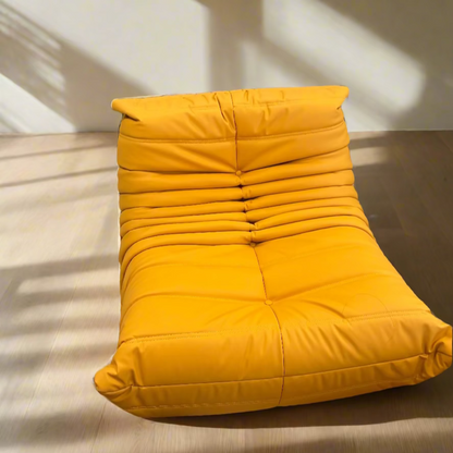 Yellow lounge chair in a room with colorful decor and furniture.