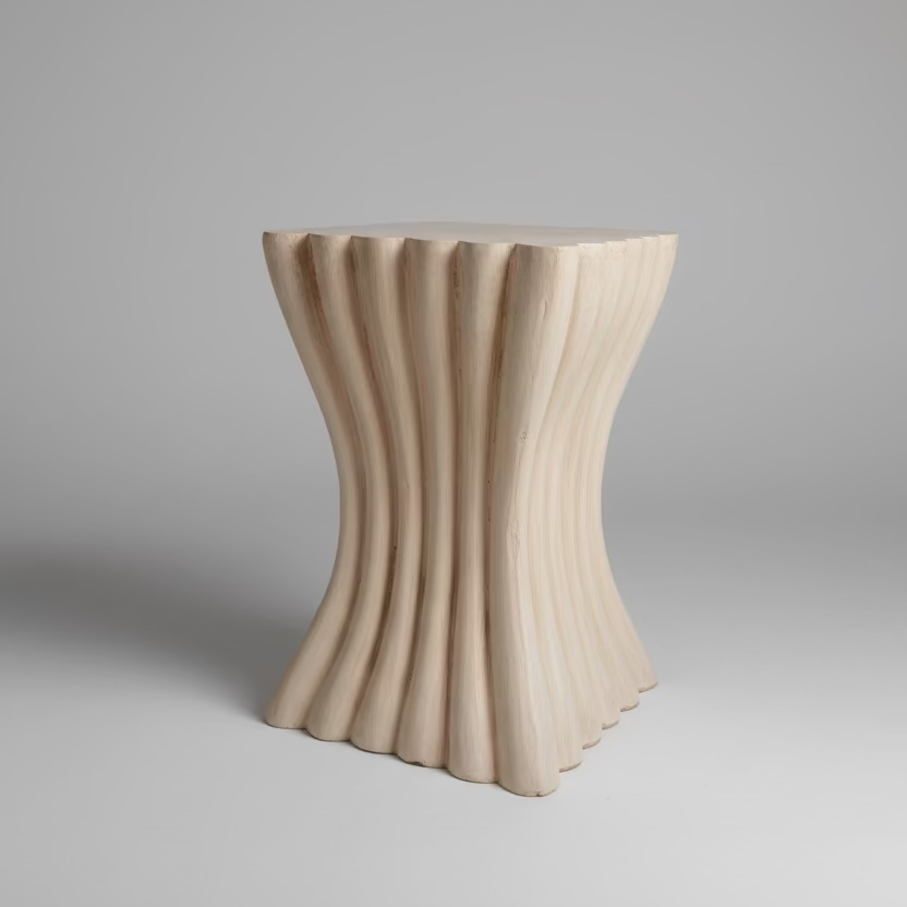 Wooden side table in a living room with a blue sofa and abstract painting.