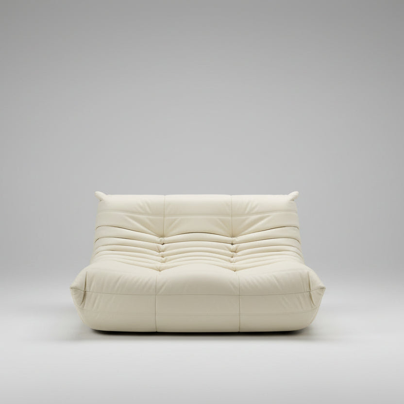 White bean bag chair in a room with large windows showing a garden view.