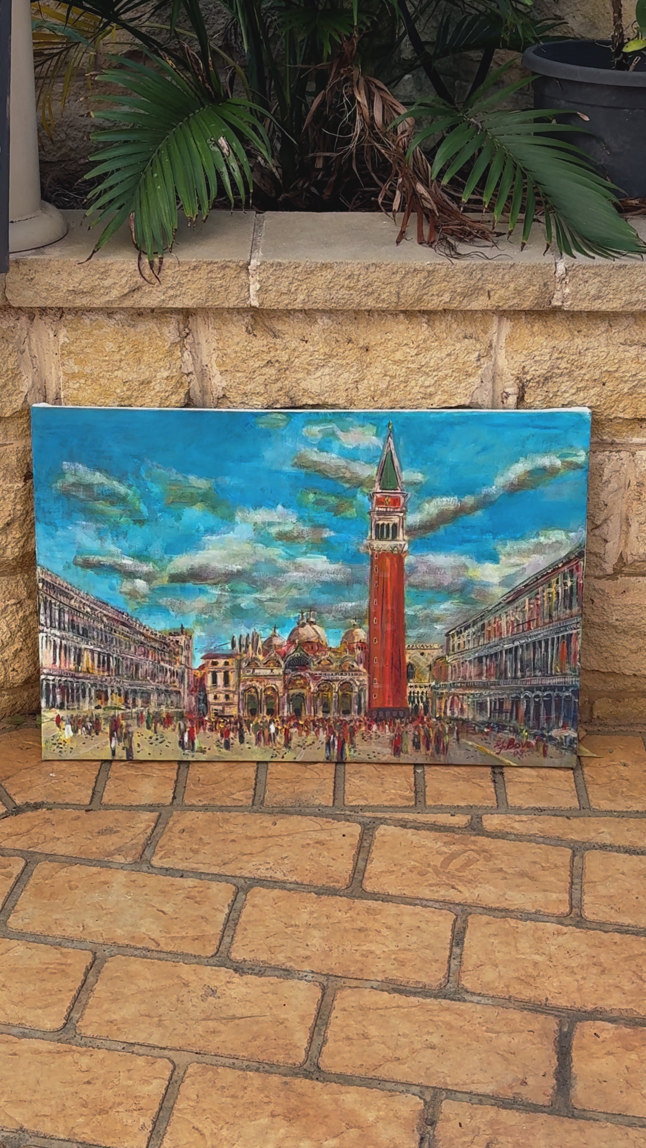 A hand-painted cityscape of Venice’s Piazza San Marco, featuring the iconic Campanile bell tower, St. Mark’s Basilica, and surrounding historic architecture under a vibrant blue sky with swirling clouds